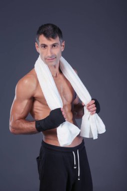 Siyah arka plan üzerine ayakta güçlü atletik adam.