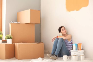 Kadın seçerek boya rengi renk örneği yeni ev ahşap yere oturmak için. Kadın evde