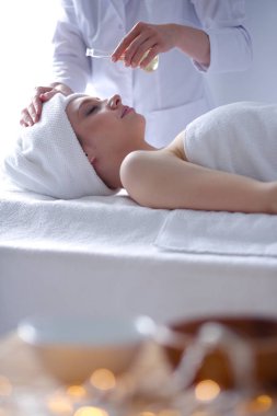 Masaj masasında uzanmış gözleri kapalı rahatlayan genç bir kadın. - Kadın. Spa salonu