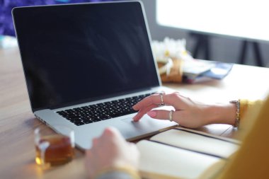 Kredi kartı tutan ve dizüstü bilgisayar kullanan genç bir kadın. Çevrimiçi alışveriş kavramı