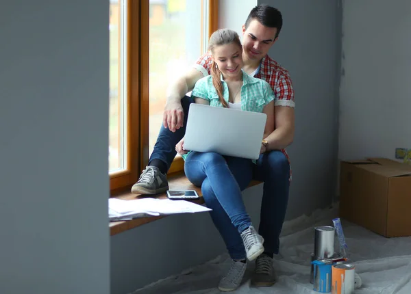Portret młodej pary w nowym domu siedzi z laptopa — Zdjęcie stockowe