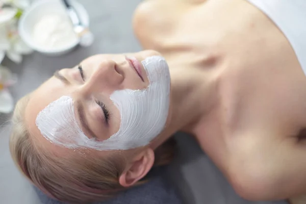 Mascarilla facial. Hermosa joven en el spa, mujer cosmética aplicando mascarilla facial . —  Fotos de Stock