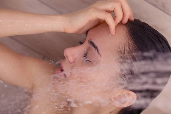 Junge schöne Frau unter der Dusche im Badezimmer. — Stockfoto