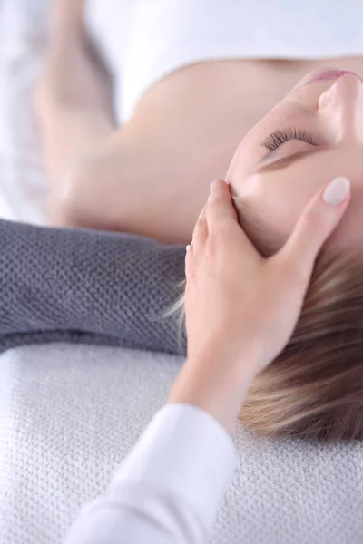 Jovem deitada em uma mesa de massagem, relaxando com os olhos fechados. Mulher. Salão de Spa — Fotografia de Stock