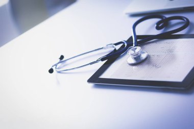 Tıbbi ekipman: Beyaz arka planda mavi steteskop ve tablet. Tıbbi ekipman