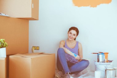 Kadın seçerek boya rengi renk örneği yeni ev ahşap yere oturmak için. Kadın evde