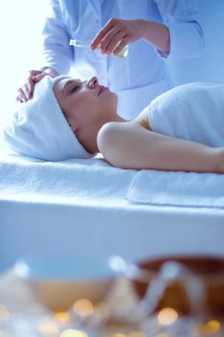 Masaj masasında uzanmış gözleri kapalı rahatlayan genç bir kadın. - Kadın. Spa salonu