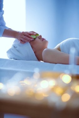 Masaj masasında uzanmış gözleri kapalı rahatlayan genç bir kadın. - Kadın. Spa salonu