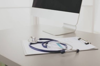 Tıbbi ekipman: Beyaz arka planda mavi steteskop ve tablet. Tıbbi ekipman.