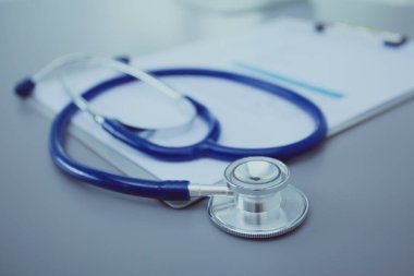 Tıbbi ekipman: Beyaz arka planda mavi steteskop ve tablet. Tıbbi ekipman