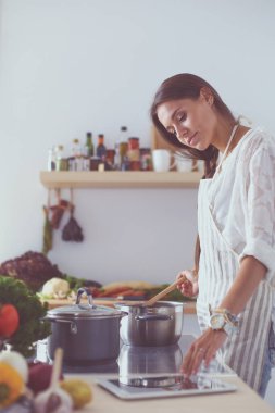 Mutfakta ahşap kaşıkla yemek pişiren kadın. Aşçı kadın.