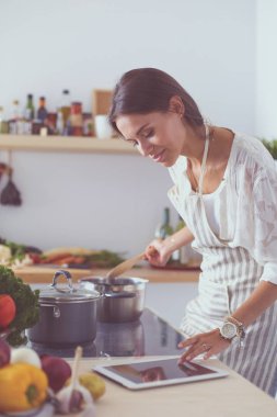 Mutfakta ahşap kaşıkla yemek pişiren kadın. Aşçı kadın.
