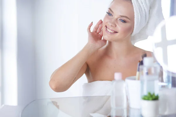 Young beautiful woman making make-up near mirror,sitting at the desk — Stock Photo, Image