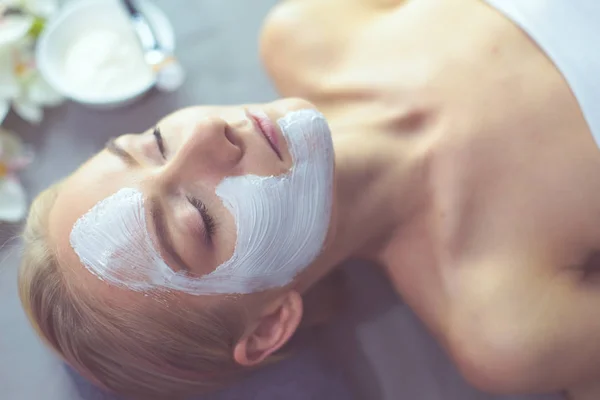 Mascarilla facial. Hermosa joven en el spa, mujer cosmética aplicando mascarilla facial . —  Fotos de Stock