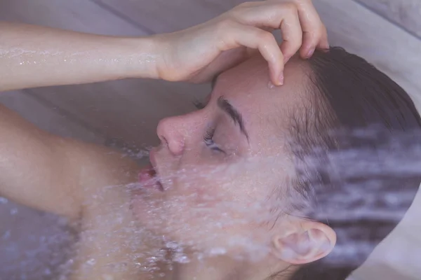 Junge schöne Frau unter der Dusche im Badezimmer. — Stockfoto