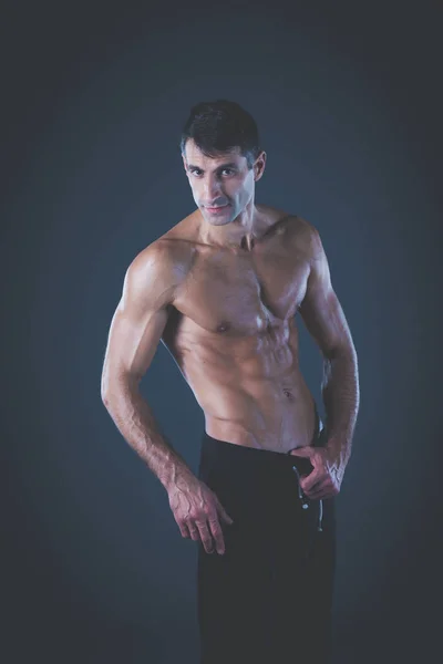 Hombre musculoso. Hombre musculoso sobre un fondo gris mostrando músculos. Instructor de fitness. Profesional de fitness. Entrenamiento. Aptitud para hombre . —  Fotos de Stock