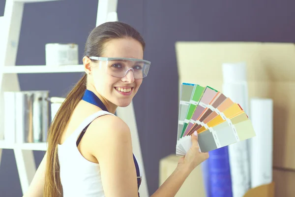 Jovem segurando uma amostra de cor com uma pintura de pintor  . — Fotografia de Stock