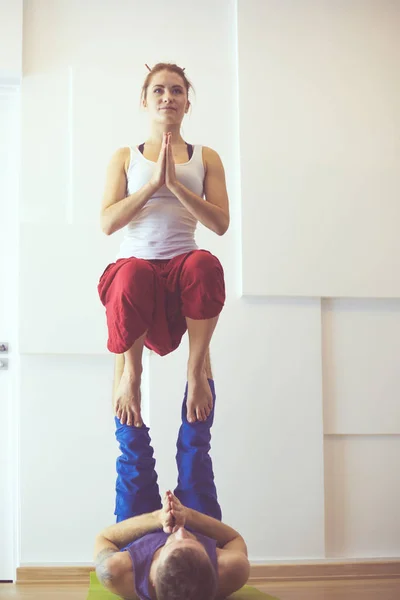 Jong sportief stel beoefenen acroyoga. Balanceren in paar. — Stockfoto