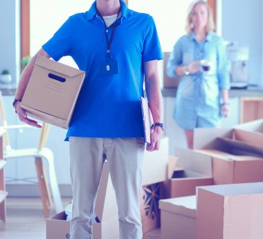 Mavi üniformalı gülümseyen kurye servis konseptine paket kutusu teslim eden teslimatçı. Mavi üniformalı gülümseyen teslimatçı.