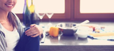 Mutfakta masada oturan genç bir kadın.