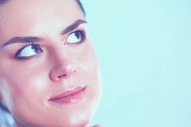 Genç bir kadın ayakta, gri arka plan üzerinde izole