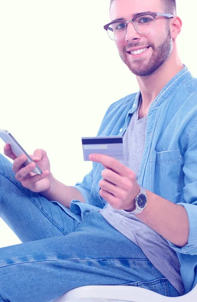 Jeune homme assis sur une chaise et tenant une carte de crédit. Démarreur. Jeune entrepreneur . — Photo