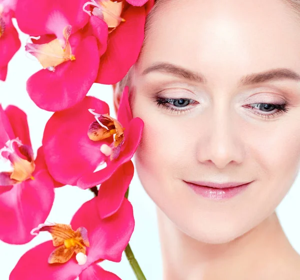 Jeune femme de beauté avec fleur près du visage — Photo