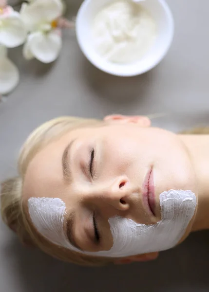 Mascarilla facial. Hermosa joven en el spa, mujer cosmética aplicando mascarilla facial — Foto de Stock