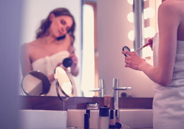 Mujer joven de pie en el baño con teléfono . — Foto de Stock