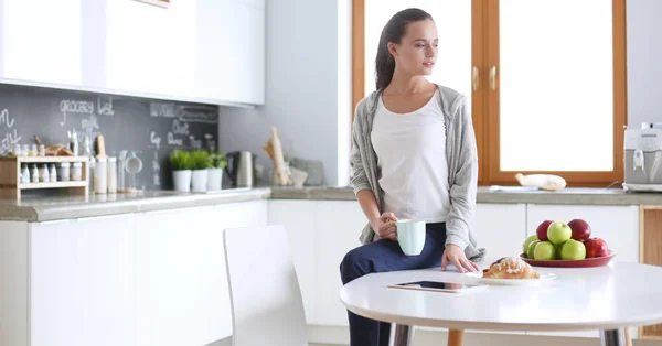 Mujer feliz bebiendo té en la cocina en casa . — Foto de Stock