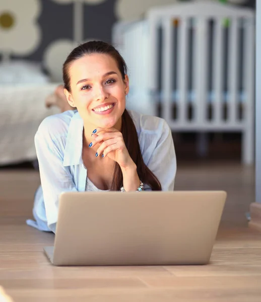 Młoda piękna kobieta w domu siedzi na podłodze z laptopa — Zdjęcie stockowe