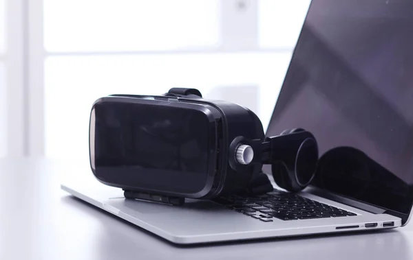 虚拟现实的护目镜与笔记本电脑放在桌上。生意。3d技术 — 图库照片