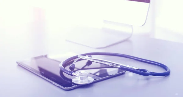 Медицинское оборудование: синий стетоскоп и таблетка на белом фоне. Медицинское оборудование — стоковое фото