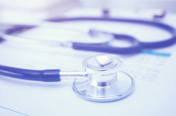 Медицинское оборудование: синий стетоскоп и таблетка на белом фоне. Медицинское оборудование