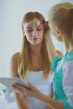 Kaşlar için kalıcı makyaj. Güzellik salonunda kalın kaşlı güzel bir kadın..