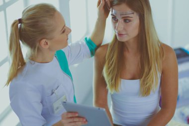 Kaşlar için kalıcı makyaj. Güzellik salonunda kalın kaşlı güzel bir kadın..