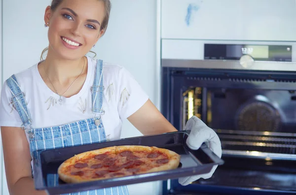 Glückliche junge Frau kocht zu Hause Pizza — Stockfoto