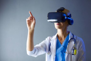 Sanal gerçeklik gözlüğü takan kadın doktor beyaz arka planda izole edilmiş..