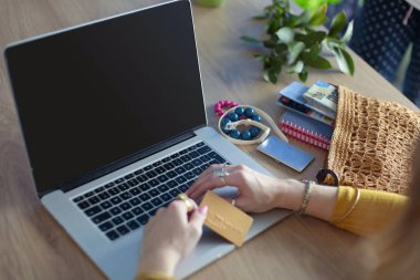 Genç bir kadın kahve molasında ya da kahve molasında dizüstü bilgisayar kullanıyor..