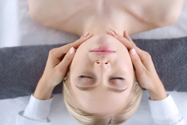 Jeune femme allongée sur une table de massage, relaxante les yeux fermés. Femme. Salon de spa — Photo