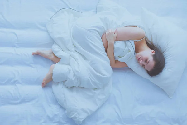 Junge Frau empfindet Schmerzen im Bett. — Stockfoto