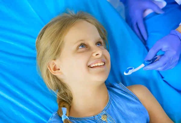 Mała dziewczynka siedzi w gabinecie dentystycznym. — Zdjęcie stockowe