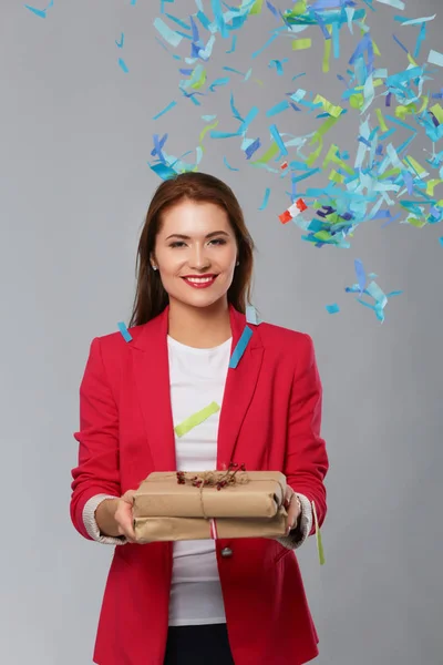 Beautiful happy woman with gift box at celebration party with confetti . Birthday or New Year eve celebrating concept — Stock Photo, Image