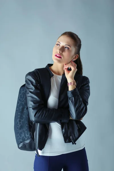 Retrato de bela jovem morena na elegante jaqueta preta em cinza . — Fotografia de Stock