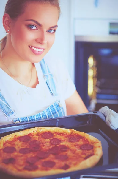 Glückliche junge Frau kocht zu Hause Pizza — Stockfoto