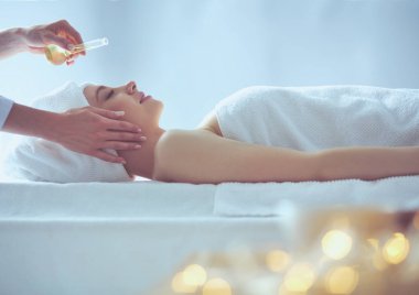 Masaj masasında uzanmış gözleri kapalı rahatlayan genç bir kadın. - Kadın. Spa salonu