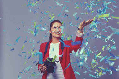 Kamera ile konfeti kutlama partisinde güzel mutlu kadınla. Doğum günü veya yeni yıl arifesi kavramı kutlama