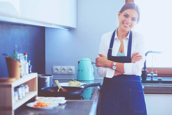 Jovem mulher de pé perto da mesa na cozinha — Fotografia de Stock