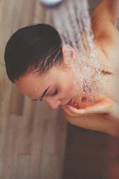 浴室のシャワーの下で若い美しい女性. — ストック写真