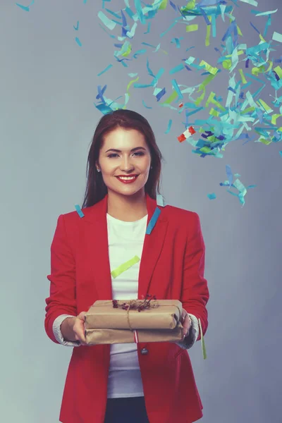 Hermosa mujer feliz con caja de regalo en la fiesta de celebración con confeti. Cumpleaños o Nochevieja celebrando el concepto — Foto de Stock